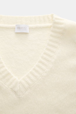 Nahaufnahme des cremefarbenen 04651/ A trip in a bag V-Neck Pullover 'Light Wool' mit V-Ausschnitt, feinem Strickbild, weichem Griff, Regular Fit, Strukturstrick an Saum und Ärmeln sowie breiten Rippbündchen, aus Wolle und Microfaser, frontal fotografiert
