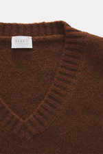 Nahaufnahme des braunen 04651/ A trip in a bag V-Neck Pullover 'Light Wool' mit V-Ausschnitt, feinem Strickbild, Strukturstrick, breiten Rippbündchen, Regular Fit, weichem Griff, Mix aus Wolle und Microfaser, von oben fotografiert.
