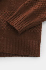 Close-up front view of the brown 04651/ A trip in a bag V-Neck Pullover 'Light Wool' showing wide ribbed cuffs, textured knit at hem and sleeves, fine knit pattern, soft touch, regular fit, made of a mix of wool and microfiber.