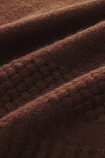 Close-up view of the brown 04651/ A trip in a bag V-Neck Pullover 'Light Wool' showing fine knit pattern, mix of wool and microfiber, soft touch, regular fit, textured knit at hem and sleeves, and wide ribbed cuffs.