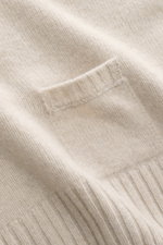 Nahaufnahme des 04651/ A trip in a bag Strickpolo 'Johnny' sand mit feinem Strickbild, kleiner Tasche und weichem Material aus Merinowolle und Cashmere.