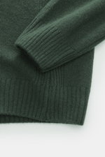 Nahaufnahme des dunkelgrünen 04651/ A trip in a bag Strickpolo 'Johnny' aus Merinowolle und Cashmere, Detailansicht von Rippbündchen und feinem Strickbild.