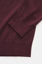 Nahaufnahme des von Braun Merino Feinstrick V-Neck Pullover bordeaux, seitliche Perspektive auf Ärmel und Bund aus reiner Merinowolle mit feinem Strickbild.