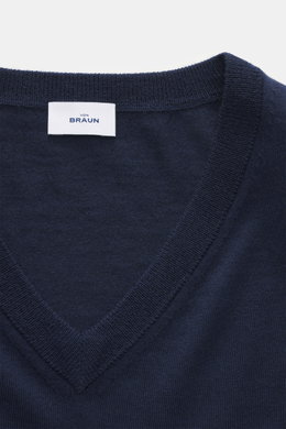 Nahaufnahme aus schräger Draufsicht des von Braun Merino Feinstrick V-Neck Pullovers navy mit feinem Strickbild, V-Ausschnitt und Label, aus reiner Merinowolle.