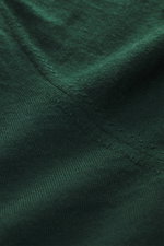 Nahaufnahme des dunkelgrünen von Braun Merino Feinstrick V-Neck Pullovers aus reiner Merinowolle, feines Strickbild, weicher Griff, leichte Qualität, Regular Fit, flexible Rippbündchen, seitliche Perspektive.