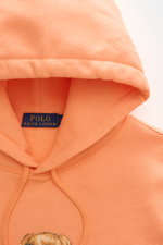 Polo Ralph Lauren Kapuzenpullover hellorange, Detailaufnahme von oben, weicher Baumwoll-Microfaser-Mix, Kapuze mit Tunnelzug, Polo-Bear-Print innen sichtbar.