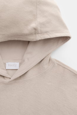 Close-up front view of 04651/ A trip in a bag Terry hooded jumper 'Terry' beige, made of soft pure cotton terrycloth with a practical hood.

<p>Comfort and coolness with summery nonchalance: The hooded jumper 'Terry' by 04651/ A TRIP IN A BAG made of pure