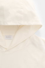 04651/ A trip in a bag Kapuzenpullover 'IF Hoodie' creme, Detailansicht der Kapuze aus gebürstetem Jersey mit weichem Griff und kleinem Weblabel, von oben fotografiert.