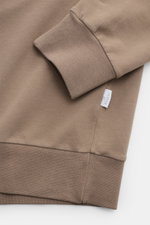 04651/ A trip in a bag Kapuzenpullover 'IF Hoodie' taupe, Detailaufnahme von Ärmel und Bund aus gebürstetem Jersey mit weichem Griff und Weblabel.