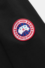 Close-up front-side view of the Canada Goose Hoodie 'Loon' black showing the red, white, and blue CANADA GOOSE Arctic Program woven label on the upper arm.

<p>Urban style meets comfort – the 'Loon' hoodie by CANADA GOOSE combines pleasant wearing comfort