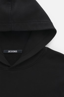 Jacquemus Kapuzenpullover 'Gros Grain' schwarz in Nahaufnahme von oben, Sweat aus reiner Baumwolle, schwere Qualität, softe Innenseite, markante Overlock-Nähte, Regular Fit, praktische Kapuze, Grosgrain mit Logo-Stitching auf der Brust, komfortable Rippbü