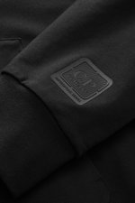 Nahaufnahme der C.P. Company Sweatjacke schwarz aus elastischem Baumwoll-Stretch-Fleece, Fokus auf weichen Rippbündchen und Logo, Produktdetail, Perspektive frontale Ansicht.