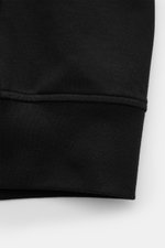 Nahaufnahme der schwarzen C.P. Company Sweatjacke im Regular Fit, Fokus auf elastischen Baumwoll-Stretch-Fleece mit flexiblem Rippbündchen.