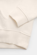 Nahaufnahme des Polo Ralph Lauren Kapuzenpullover weiß, zeigt Ärmelbündchen, Kängurutasche und weichen Baumwoll-Microfaserstoff.