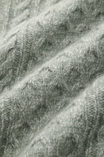 Nahaufnahme des grob gestrickten Zopfstrickmusters des 04651/ A trip in a bag Rollkragenpullovers 'Mouline Cable Turtle' graugrün meliert aus Wolle-Cashmere-Bouclé, weich und voluminös.