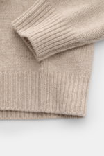 Close-up image of the sleeve and hem of the 04651/ A trip in a bag Hooded jumper beige mottled, photographed from above showing its soft, medium-fine knit texture and wide ribbed bands.

<p>Provides reliable warmth: This hooded jumper from 04651/ A TRIP I