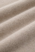 Close-up front view of soft beige mottled knit fabric showing texture of the 04651/ A trip in a bag Hooded jumper beige mottled. <p>Provides reliable warmth: This hooded jumper from 04651/ A TRIP IN A BAG, with its turtleneck and hood design, is a comfort