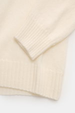 Nahaufnahme des cremefarbenen 04651/ A trip in a bag Cashmere Rollkragenpullovers, von oben fotografiert, zeigt weichen Griff, feines Strickbild, Rippbündchen und Rollkragen aus reinem Cashmere, Regular Fit, ideal für Office und Alltag.