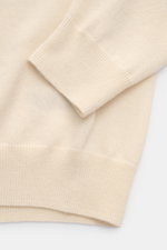 Nahaufnahme des von Braun Cashmere Rollkragenpullovers creme von schräg oben, feines Strickbild, elastische Rippbündchen, Slim Fit, sehr weich.