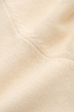 Nahaufnahme des fein gestrickten, cremefarbenen von Braun Cashmere Rollkragenpullovers mit weichem Griff, Slim Fit und elastischen Rippbündchen.