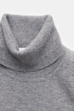 Nahaufnahme von einem von Braun Cashmere Rollkragenpullover grau meliert, fein gestrickt aus reinem Cashmere mit weichem Griff, Slim Fit, anliegendem Rollkragen und elastischen Rippbündchen, aus der Mongolei, frontal fotografiert.