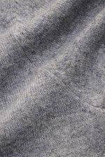 Nahaufnahme des von Braun Cashmere Rollkragenpullovers grau meliert, feines Strickbild, weicher Griff, elastische Rippbündchen sichtbar.