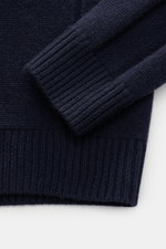 Nahaufnahme des von Braun Cashmere Rollkragenpullovers navy, fotografiert von oben, zeigt weiche Links- und Zopfmuster, Slim Fit, anliegenden Rollkragen und flexible Rippbündchen aus reinem, mittelfeinem Cashmere.