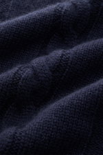 Nahaufnahme des von Braun Cashmere Rollkragenpullovers navy aus feinster Innerer Mongolei Cashmere, gezeigt aus Detailperspektive mit Linksstrick- und Zopfstrickmuster, Slim Fit, anliegendem Rollkragen und flexiblen Rippbündchen.