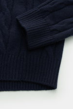 Close-up top-down view of the navy von Braun Cashmere turtleneck jumper showing soft pure cashmere fabric with a classic cable knit pattern, ribbed flexible bands, regular fit, and a close-fitting turtleneck. Comfortable through the winter: Soft cashmere 
