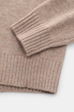 Nahaufnahme von Ärmel und Saum des von Braun Cashmere Rollkragenpullovers beige meliert, mittelfeines Strickbild, Regular Fit, weicher Griff.