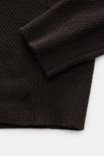 Nahaufnahme des von Braun Cashmere Rollkragenpullovers dunkelbraun aus reinem mongolischem Cashmere, mittelfeiner Strukturstrick, Slim Fit, mit Rippstrick-Rollkragen und komfortablen Rippbündchen, fotografiert von oben.
