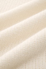 Detailaufnahme des groben Strickbilds und weichen Griffs des cremefarbenen 04651/ A trip in a bag Cashmere Rollkragenpullovers.