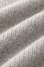 Close-up image of the 04651/ A trip in a bag Cashmere Rollkragenpullover hellgrau meliert showing its thick knit texture and soft light grey cashmere fibers, photographed from a top-down perspective. <p>Essenziell für kühle Tage: Der Rollkragenpullover au