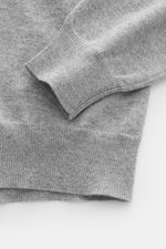 Nahaufnahme des Malo Cashmere Rollkragenpullovers grau meliert, Perspektive auf Ärmel mit Slim Fit, feinem Strickbild, anliegendem Rollkragen und Rippbündchen.