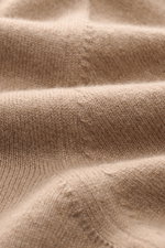 Nahaufnahme des feinen Strickbilds vom Malo Cashmere Rollkragenpullover beige, fotografiert aus nächster Perspektive, zeigt weichen Griff und Rippbündchen.
