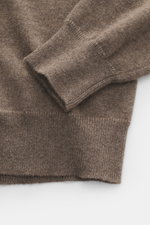 Nahaufnahme des graubraunen Malo Cashmere Rollkragenpullovers, fotografiert aus seitlicher Perspektive, zeigt feines Strickbild, Slim Fit, anliegenden Rollkragen und komfortable Rippbündchen, reiner Cashmere mit sehr weichem Griff.