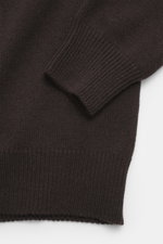 Close-up top-down view of Malo Cashmere Turtleneck Sweater dark brown sleeve and body, showing medium-fine knit, ribbed cuffs, and soft texture.