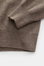 Close-up top-down view of the Malo Cashmere Turtleneck Sweater Grey-Brown Melange sleeve and hem showing medium-fine knit, ribbed cuffs, pure cashmere, very soft feel, slim fit, and close-fitting turtleneck.