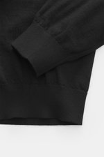 Nahaufnahme des Malo Rollkragenpullover schwarz, fotografiert von oben, zeigt feines Strickbild, anliegenden Rollkragen, Slim Fit, Rippbündchen, reine Schurwolle, sehr weicher Griff.