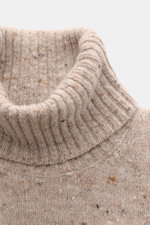 Nahaufnahme des beigen melierten Drumohr Rollkragenpullovers mit ultrasoftem Strick, mittelfeinem Muster, Slim Fit und flexiblen Rippbündchen, von schräg oben fotografiert.