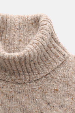 Nahaufnahme des beigen melierten Drumohr Rollkragenpullovers mit ultrasoftem Strick, mittelfeinem Muster, Slim Fit und flexiblen Rippbündchen, von schräg oben fotografiert.