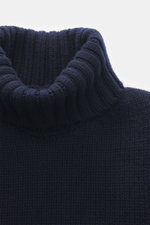 Nahaufnahme aus schräger Frontperspektive des Drumohr Cashmere Rollkragenpullovers navy mit reiner Cashmerequalität, sehr weichem Griff, mittelgrobem Strickbild, Slim Fit, Rollkragen und flexiblen Rippbündchen.