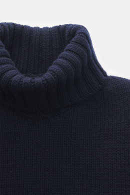 Nahaufnahme aus schräger Frontperspektive des Drumohr Cashmere Rollkragenpullovers navy mit reiner Cashmerequalität, sehr weichem Griff, mittelgrobem Strickbild, Slim Fit, Rollkragen und flexiblen Rippbündchen.