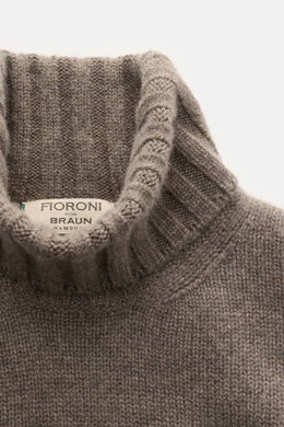 Close-up top view of the Fioroni Cashmere Rundhalspullover grau meliert, showcasing its ribbed turtleneck and soft, fine knit texture. <p>Souveräne Eleganz in ihrer luxuriösesten Form: Der Rollkragenpullover von FIORONI aus erlesenem Cashmere vereint meis