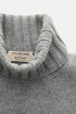 Close-up top-down view of Fioroni Cashmere Rundhalspullover dunkelgrau meliert showcasing ribbed turtleneck and label with fine medium-knit texture.

Description: <p>Souveräne Eleganz in ihrer luxuriösesten Form: Der Rollkragenpullover von FIORONI aus e