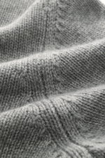 Close-up view of the Fioroni Cashmere Rundhalspullover dunkelgrau meliert, showcasing its fine mid-knit texture and soft fibers from an angled perspective. <p>Souveräne Eleganz in ihrer luxuriösesten Form: Der Rollkragenpullover von FIORONI aus erlesenem 