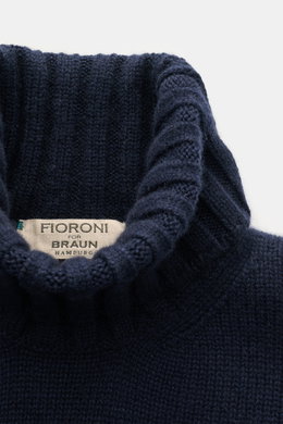 Close-up top-down view of the navy Fioroni Cashmere Rundhalspullover showcasing its ribbed turtleneck and label. <p>Souveräne Eleganz in ihrer luxuriösesten Form: Der Rollkragenpullover von FIORONI aus erlesenem Cashmere vereint meisterhafte italienische 