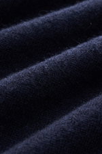 Close-up image of the fine knit pattern and soft texture of the Fioroni Cashmere Turtleneck Sweater 'Duvet' navy, photographed from a side angle showing luxurious warmth, pure cashmere, slim fit, ribbed turtleneck, and flexible ribbed cuffs.