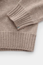 Close-up top-down view of the Fioroni Cashmere Turtleneck Sweater 'Duvet' taupe mélange showing fine knit pattern, ribbed turtleneck, and flexible ribbed cuffs, featuring pure cashmere and a very soft feel.