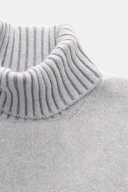 Close-up front view of the Gran Sasso Cashmere turtleneck sweater light blue mélange showing a fitted turtleneck with medium-fine knit pattern, pure cashmere, very soft feel, regular fit, and comfortable ribbed cuffs.